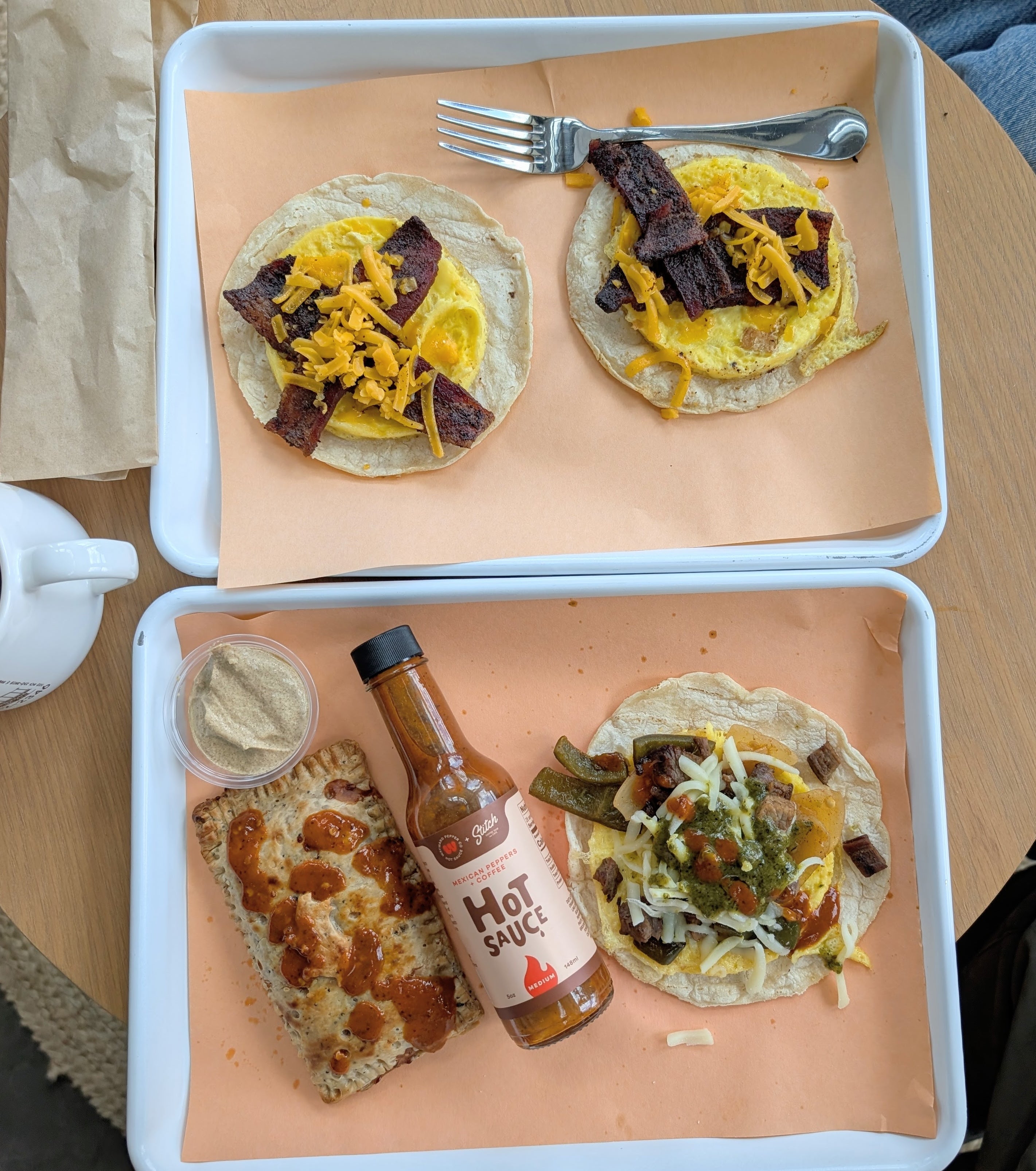 Overhead shot of street tacos with a Mexican Peppers & Coffee hot sauce bottle on the tray